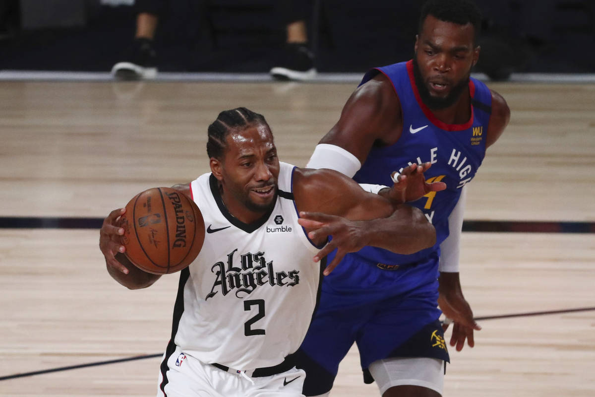 Los Angeles Clippers' forward Kawhi Leonard (2) drives to the basket past Denver Nuggets forwar ...