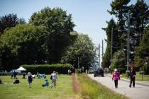 A ditch marks the Canada-U.S. border and separates people walking on the road, right, in Surrey ...