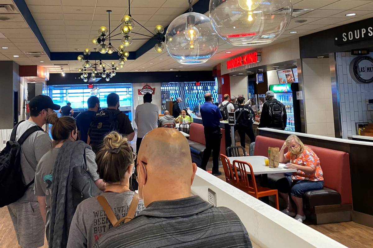 Travelers wait in line at a Burger King in Terminal 1 at McCarran International Airport on July ...