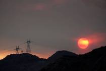 The sun sets through smoke created by the Ranch Fire, Thursday, Aug. 13, 2020, in Azusa, Calif. ...