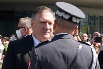 US Secretary of State Mike Pompeo talks to an officer at Pilsudski square in Warsaw, Poland, be ...