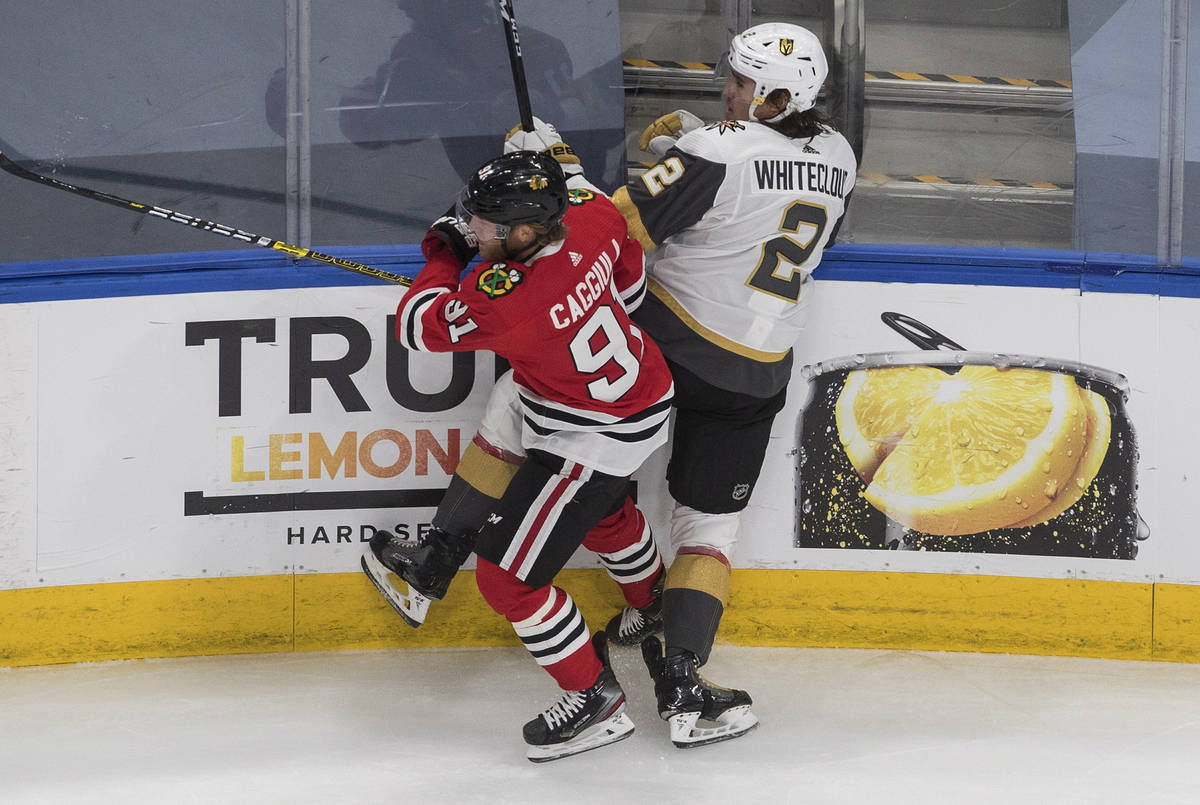 Vegas Golden Knights' Zach Whitecloud (2) is checked by Chicago Blackhawks' Drake Caggiula (91) ...