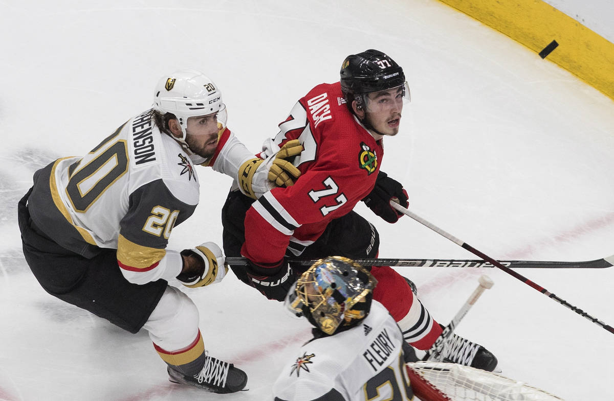 Vegas Golden Knights' Chandler Stephenson (20) and Chicago Blackhawks' Kirby Dach (77) chase th ...