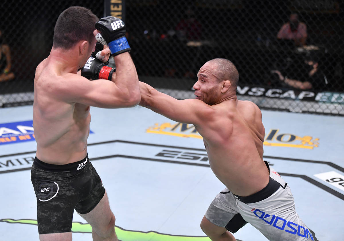 LAS VEGAS, NEVADA - AUGUST 15: (R-L) John Dodson punches Merab Dvalishvili of Georgia in their ...