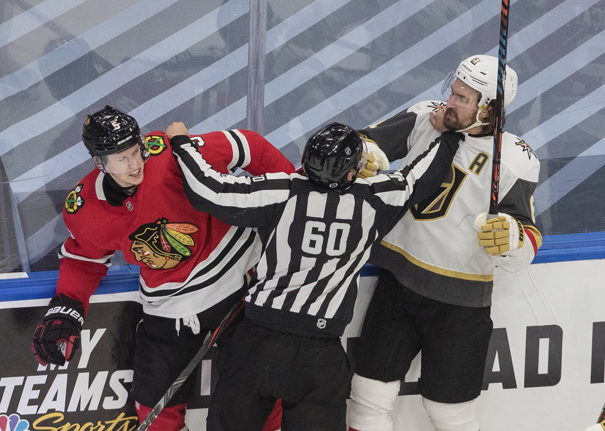 Vegas Golden Knights' Mark Stone (61) and Chicago Blackhawks' Connor Murphy (5) mix it up durin ...