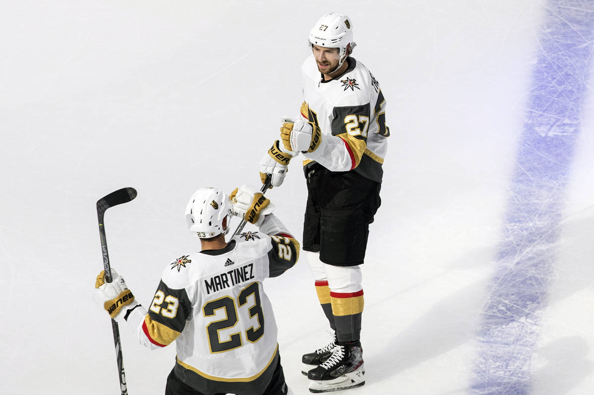 Vegas Golden Knights' Shea Theodore (27) and Alec Martinez (23) celebrate a goal during first-p ...
