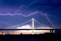 Lightning forks over the San Francisco-Oakland Bay Bridge as a storm passes over Oakland, Calif ...