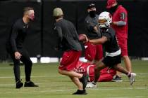 Arizona Cardinals quarterback Kyler Murray (1) tosses the ball to a coach as head coach Kliff K ...