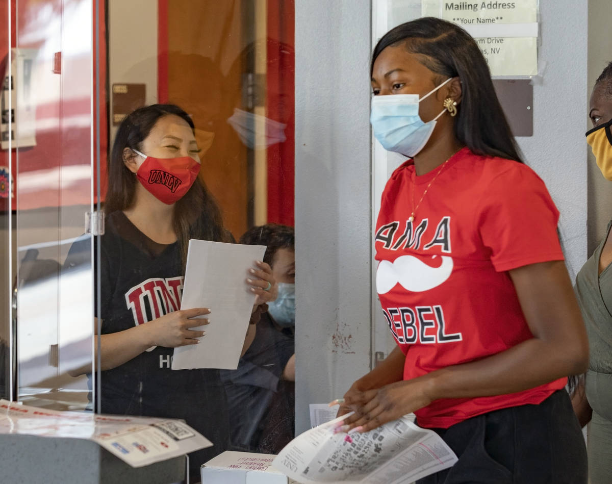 Mail clerk Rachel Deguchi, left, greets UNLV freshman Tyra Bevans, 18, of Los Angeles, during m ...