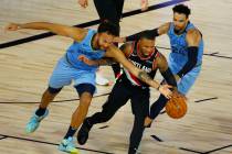 Portland Trail Blazers' Damian Lillard is pressured by Memphis Grizzlies' Kyle Anderson, left, ...