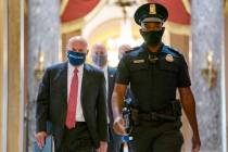 In this Aug. 5, 2020, file photo Postmaster General Louis DeJoy, left, is escorted to House Spe ...