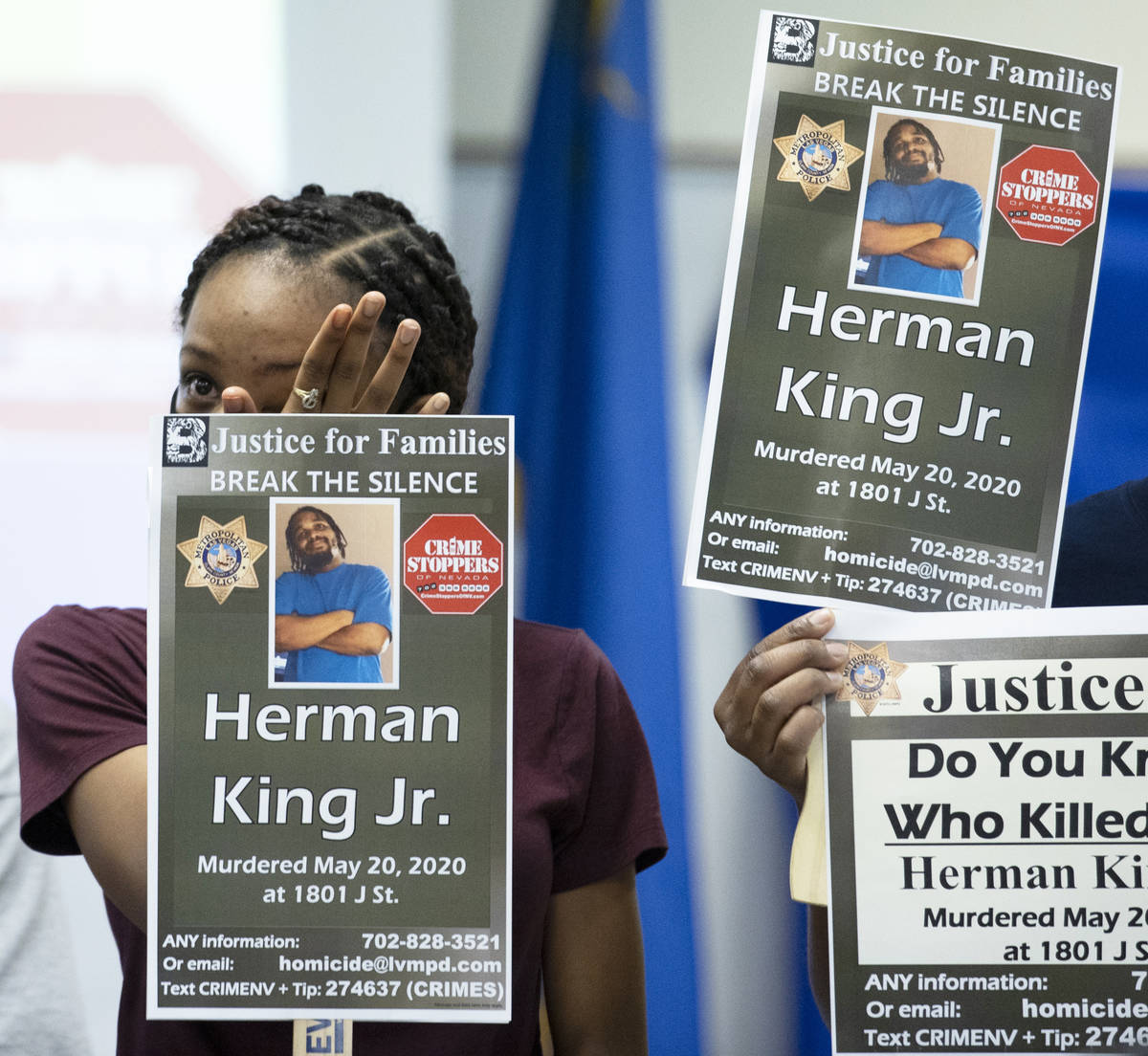 A relative of Herman King Jr. holds a sign while wiping tears from her eyes during a press brie ...