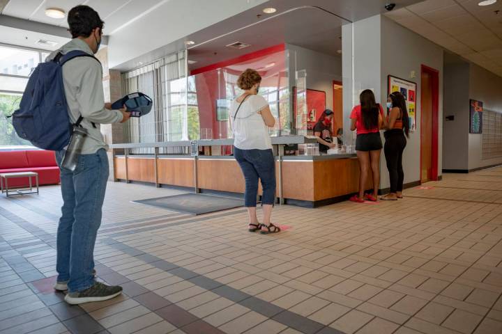 Individuals check-in at Dayton Hall during freshman move-in day at UNLV in Las Vegas on Monday, ...