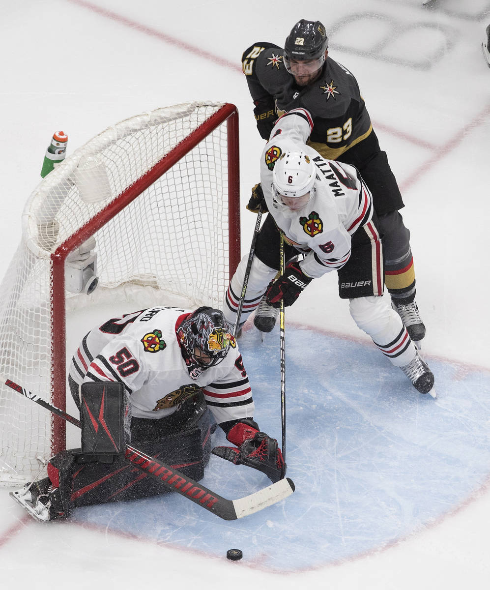 Vegas Golden Knights' Alec Martinez (23) and Chicago Blackhawks' Olli Maatta (6) look for a reb ...