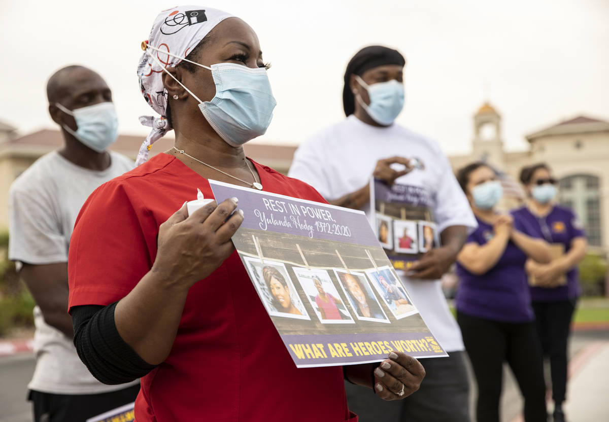 Deshon Johnson, front/left, listens to a speaker during a candlelight vigil in honor of Dignity ...