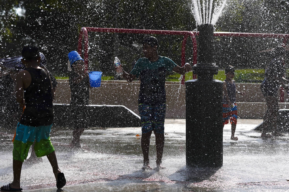 Children cool off in a park Tuesday, Aug. 18, 2020, in Fountain Valley, Calif. The state is in ...