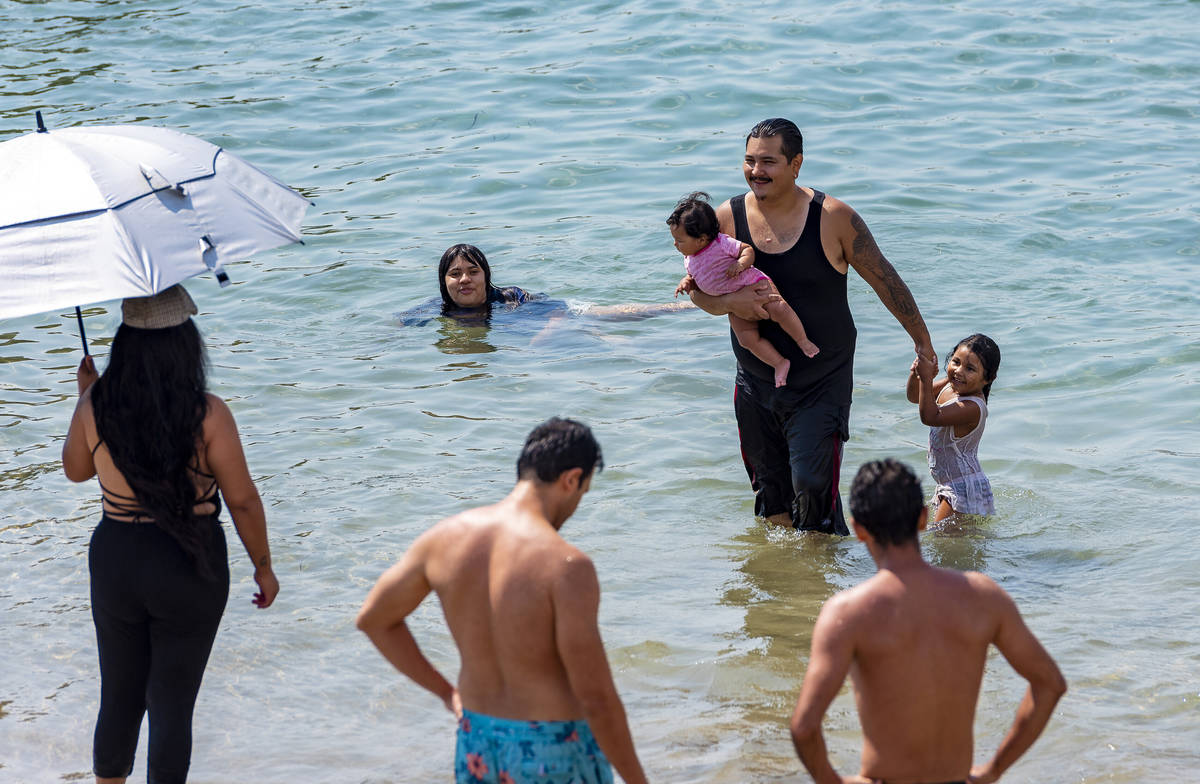 Families cool off from the hot weather, in the waters in Corona del Mar in Newport Beach, Calif ...