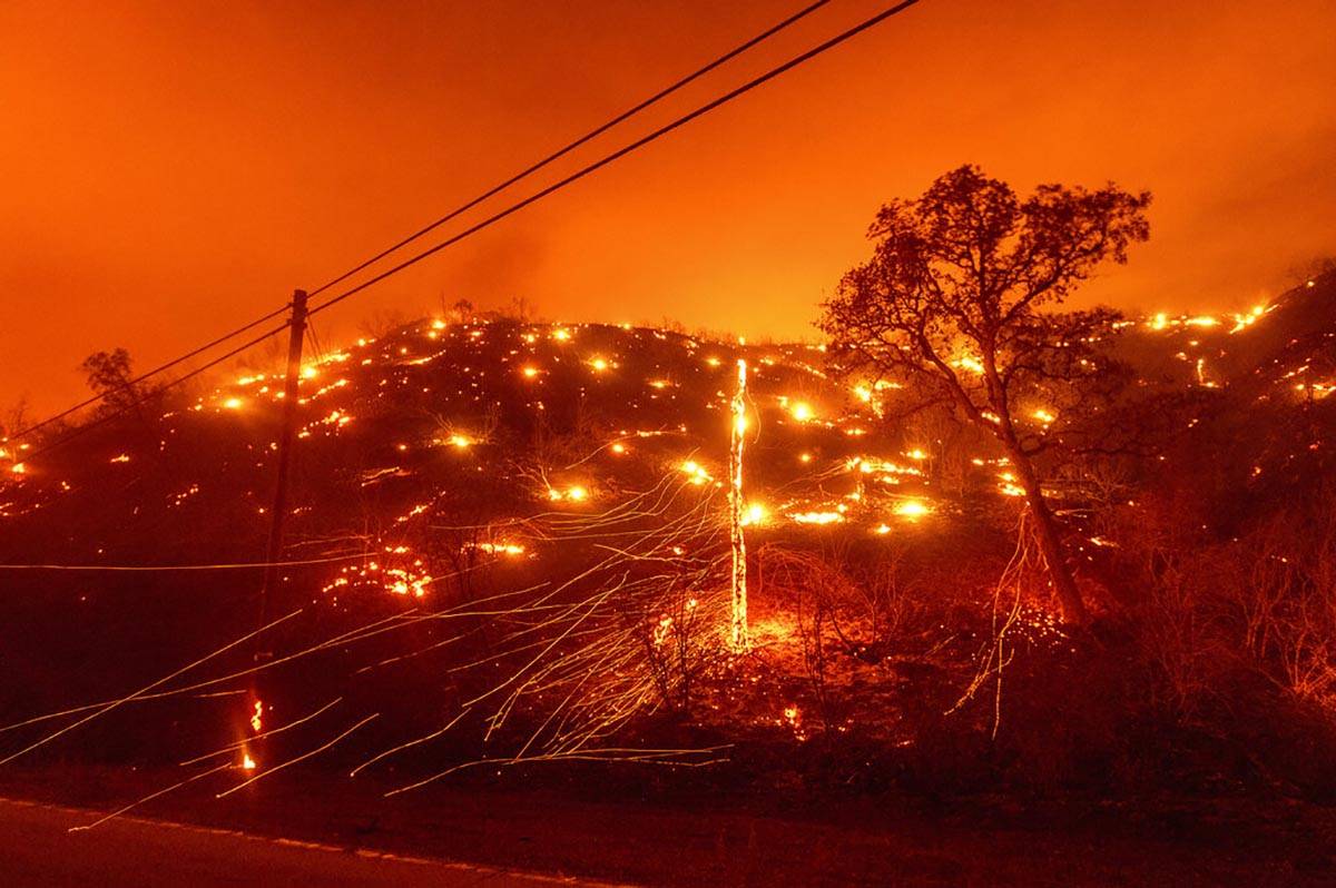 Seen in a long exposure photograph, embers burn along a hillside as the LNU Lightning Complex f ...