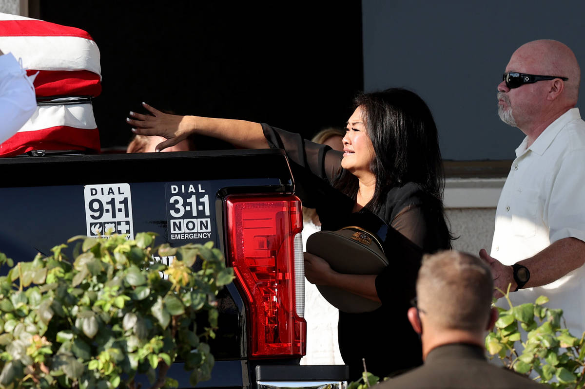Minddie Lloyd reaches out at the casket of her husband, Metropolitan Police Department Lt. Erik ...