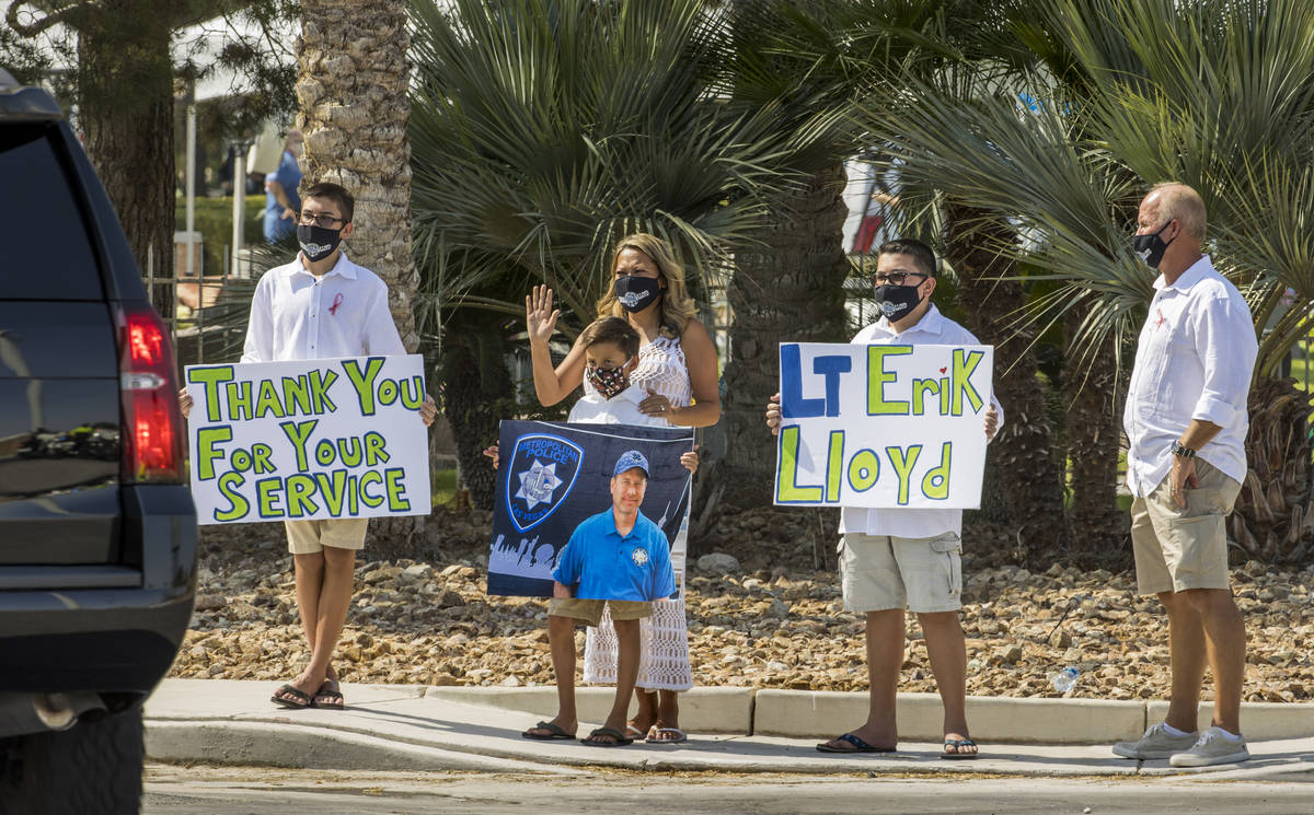Well wishers wave to vehicles of people entering a burial service for Metro Lt. Erik Lloyd at t ...