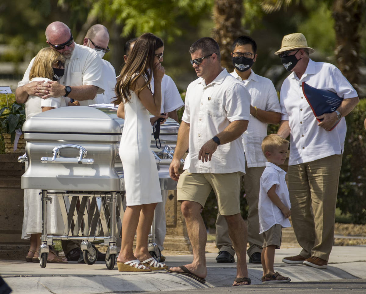 Mourners gather about the casket during a burial service for Metro Lt. Erik Lloyd at the Palm N ...
