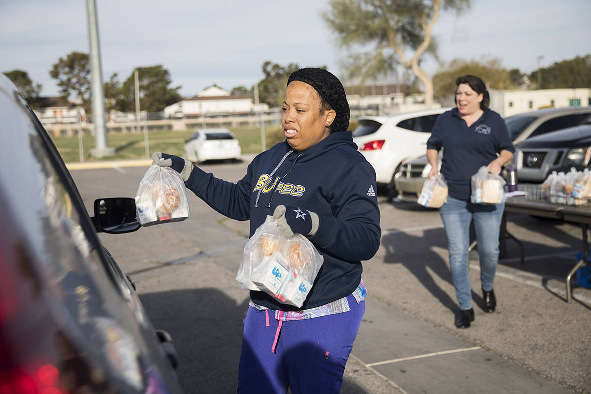 Clark County School District employees hand out breakfast and lunch packages to families at Cla ...