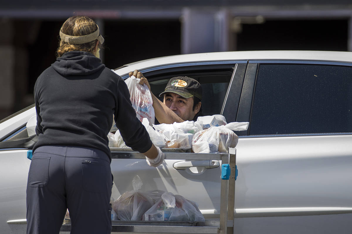 A Clark County School District worker distributes school food donations for students or parents ...