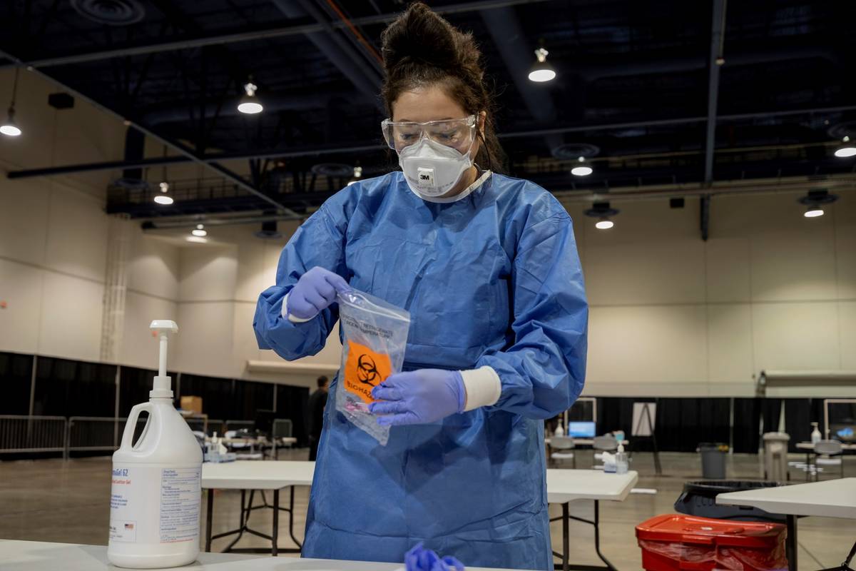 UMC respiratory therapist Diana Vega seals a COVID-19 test in a biohazard bag during a preview ...