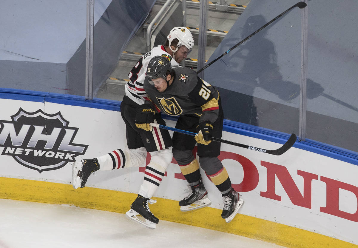 Chicago Blackhawks' Slater Koekkoek (68) is checked by Vegas Golden Knights' Nick Cousins (21) ...