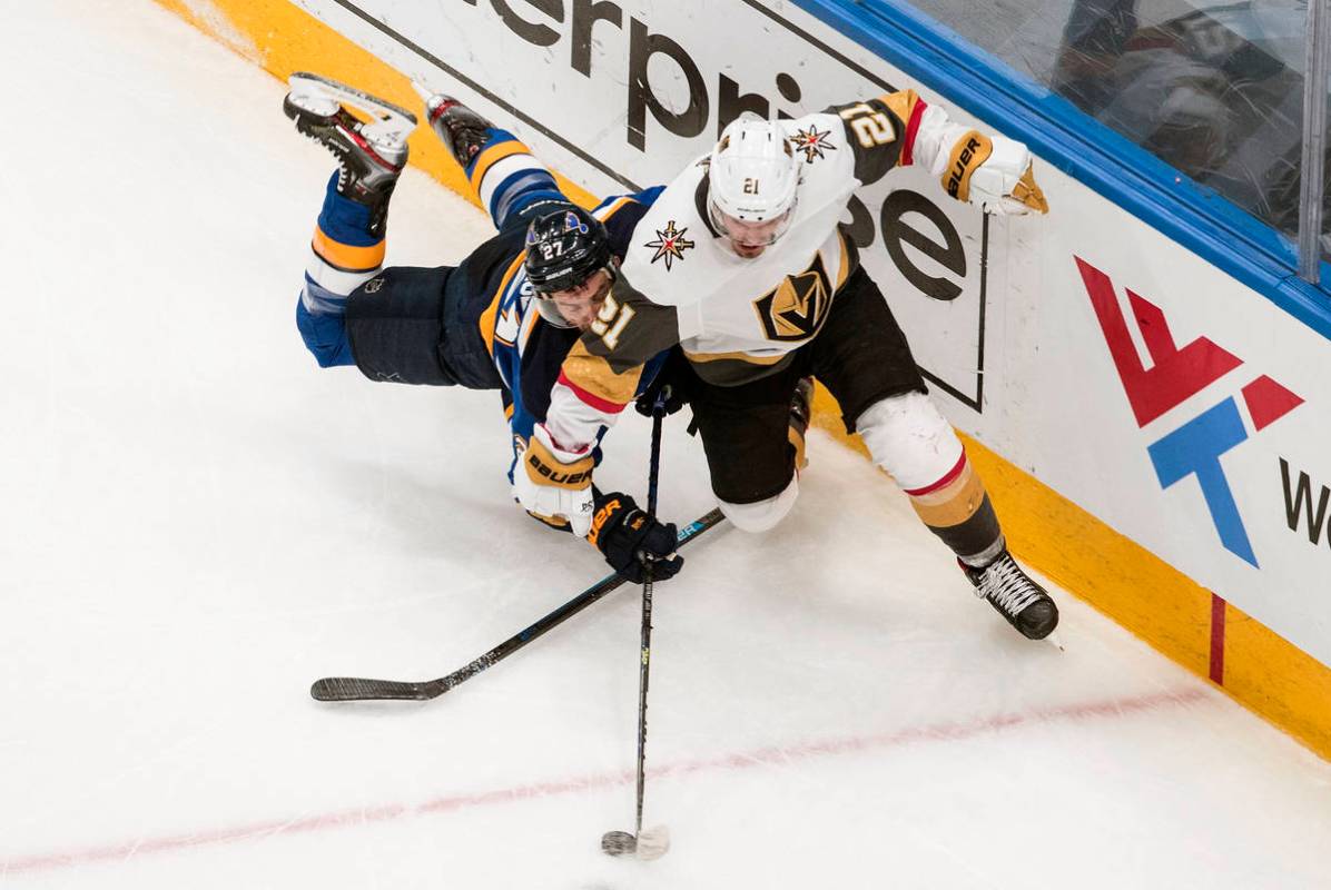 St. Louis Blues' Alex Pietrangelo (27) and Vegas Golden Knights' Nick Cousins (21) battle for t ...