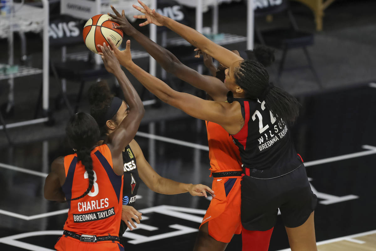 Las Vegas Aces' A'ja Wilson (22) and Connecticut Sun's Kaila Charles (3) reach for a rebound du ...