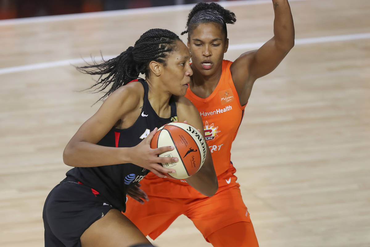 Las Vegas Aces' A'ja Wilson, left, drives against Connecticut Sun's Alyssa Thomas during the fi ...
