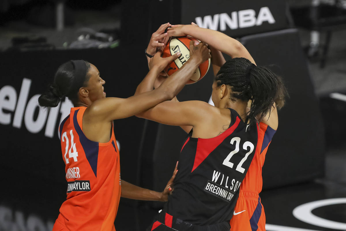 Las Vegas Aces' A'ja Wilson (22) fights for the ball against Connecticut Sun's DeWanna Bonner ( ...