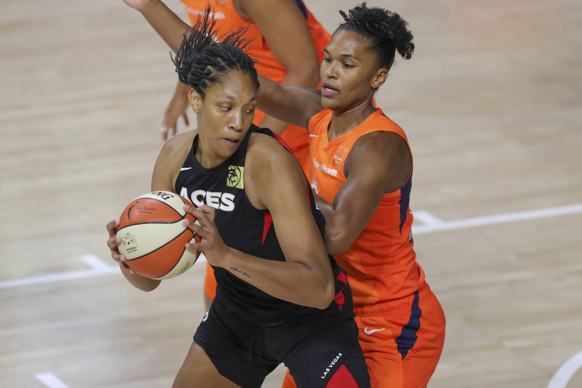 Las Vegas Aces' A'ja Wilson, left, drives against Connecticut Sun's Alyssa Thomas during the fi ...