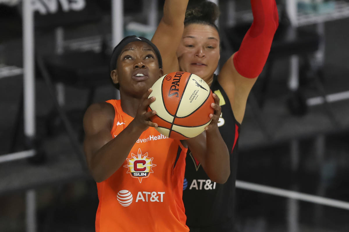 Connecticut Sun's Kaila Charles, left, shoots against the defense of Las Vegas Aces' Kayla McBr ...