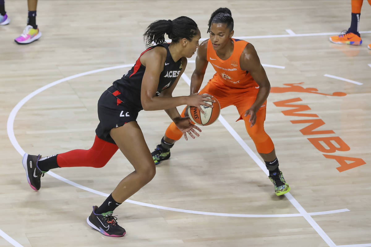 Las Vegas Aces' A'ja Wilson, left, drives against Connecticut Sun's Alyssa Thomas during the fi ...