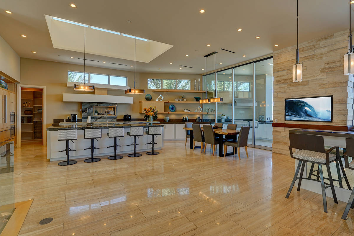 The large kitchen has a seamless transition to the massive outdoor kitchen and patio, which fea ...