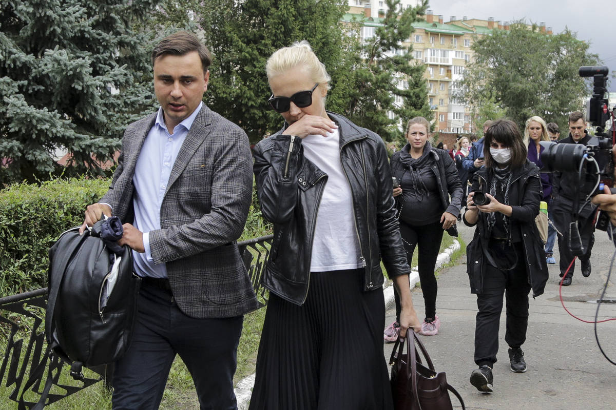 Alexei Navalny's wife Yulia, center, and Navalny's colleague Ivan Zhdanov, left, arrive to the ...