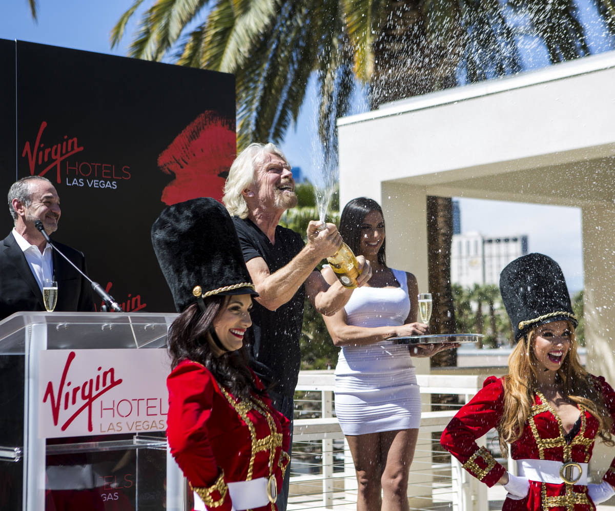 Virgin Group Founder Sir Richard Branson pops a champagne bottle following a press conference a ...