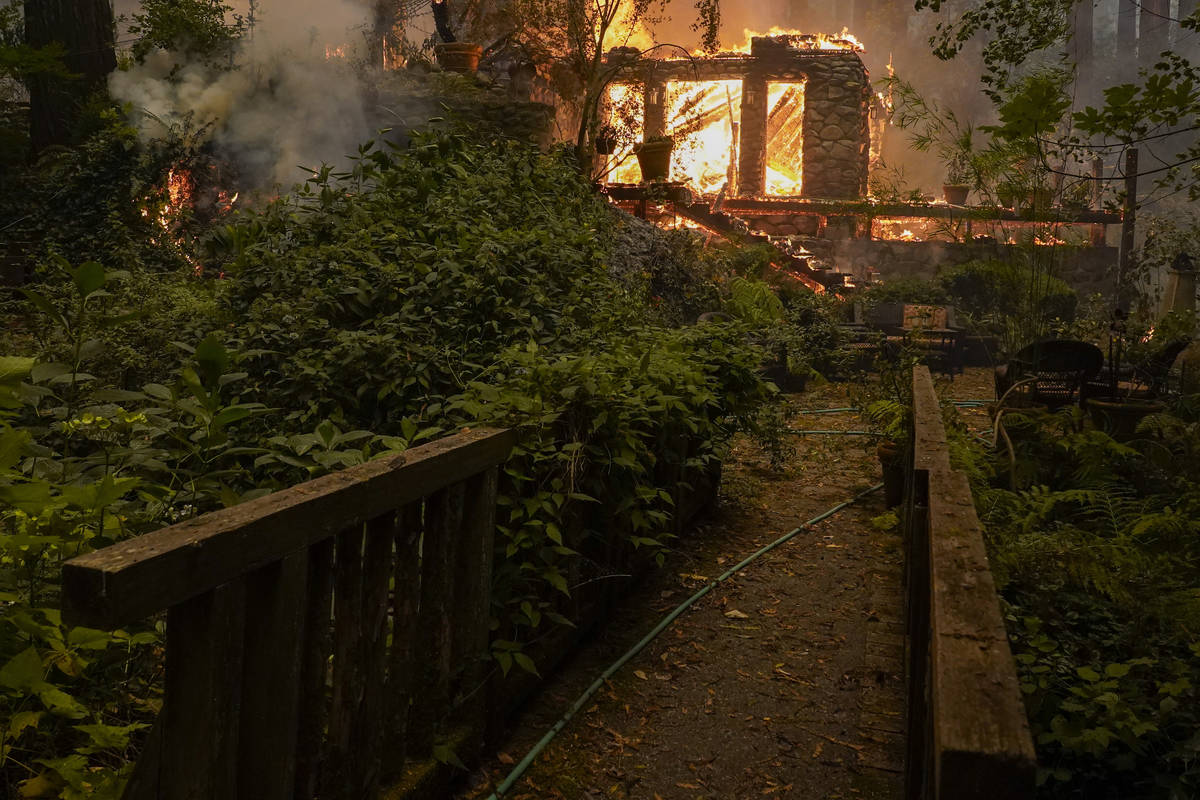 A home burns as the CZU August Lightning Complex Fire passes by, Thursday, Aug. 20, 2020, in Be ...