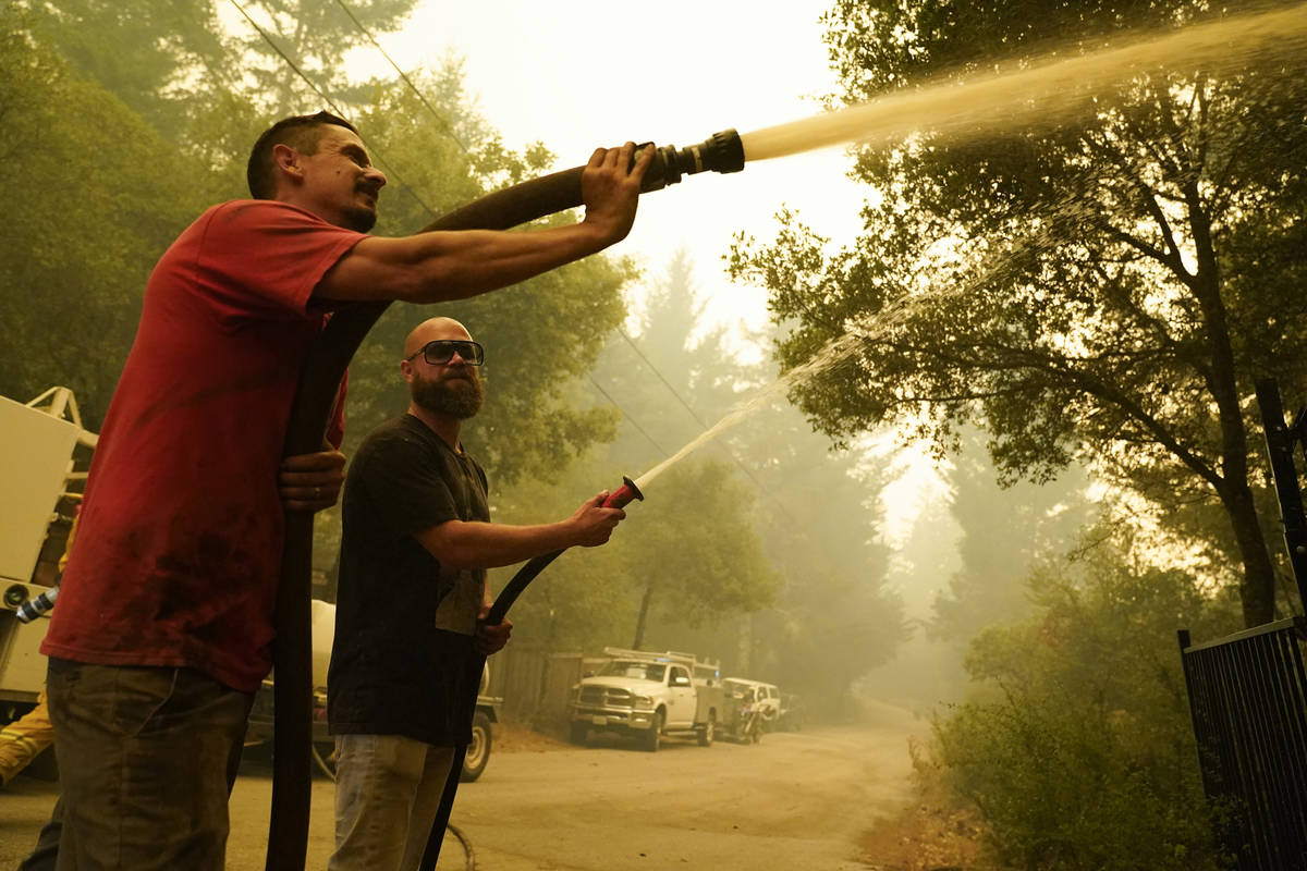 Civilian volunteers Brian Alvarez, left, and Nate Bramwell fight the CZU August Lightning Compl ...