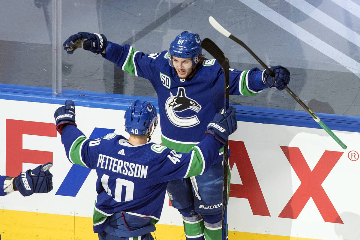 Vancouver Canucks' Troy Stecher (51) and Elias Pettersson (40) celebrate a goal against the St. ...