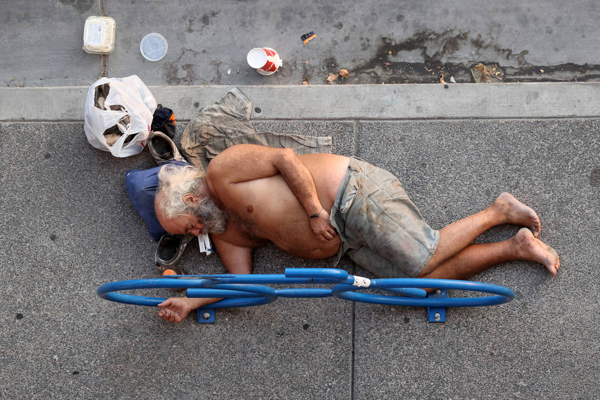 A person rests in the shade Ogden Avenue near Las Vegas Boulevard Tuesday, Aug. 18, 2020. (K.M. ...