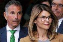 Actress Lori Loughlin, front, and her husband, clothing designer Mossimo Giannulli, left, depar ...