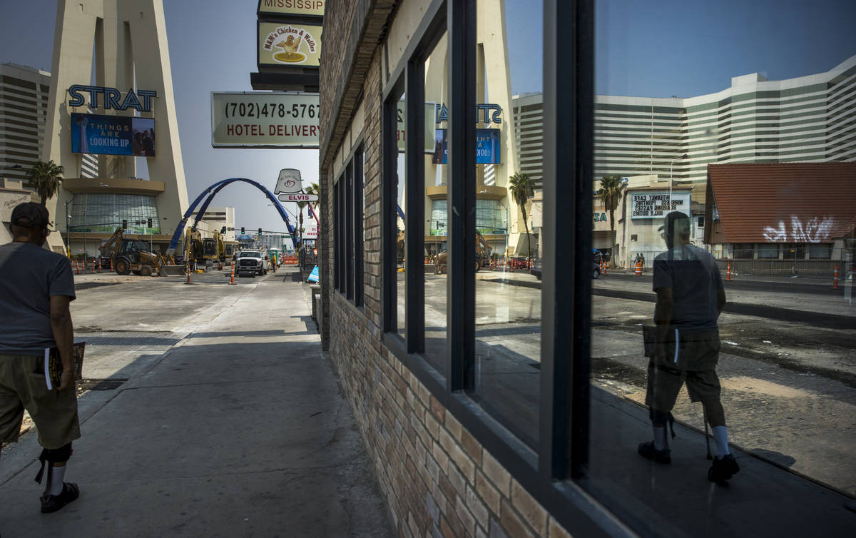 A pedestrian is reflected in a window as he walks towards the construction of the 80-foot-tall ...