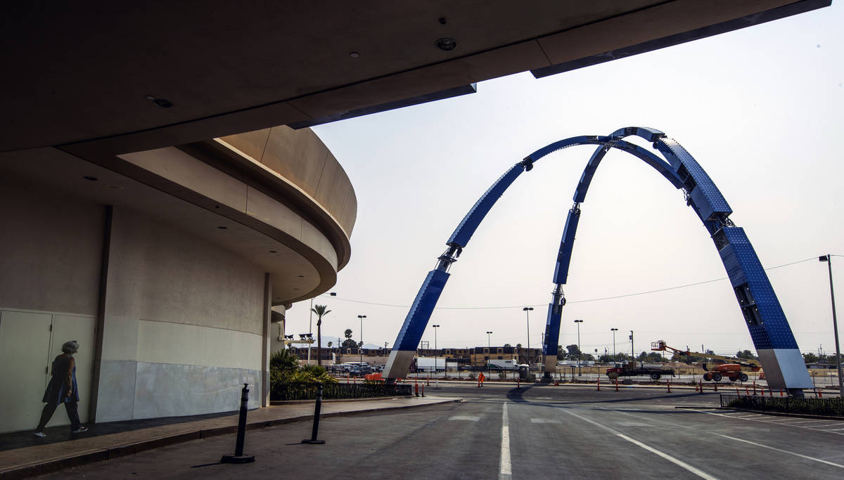A pedestrian walk at The Strat as construction continues nearby of the 80-foot-tall gateway arc ...