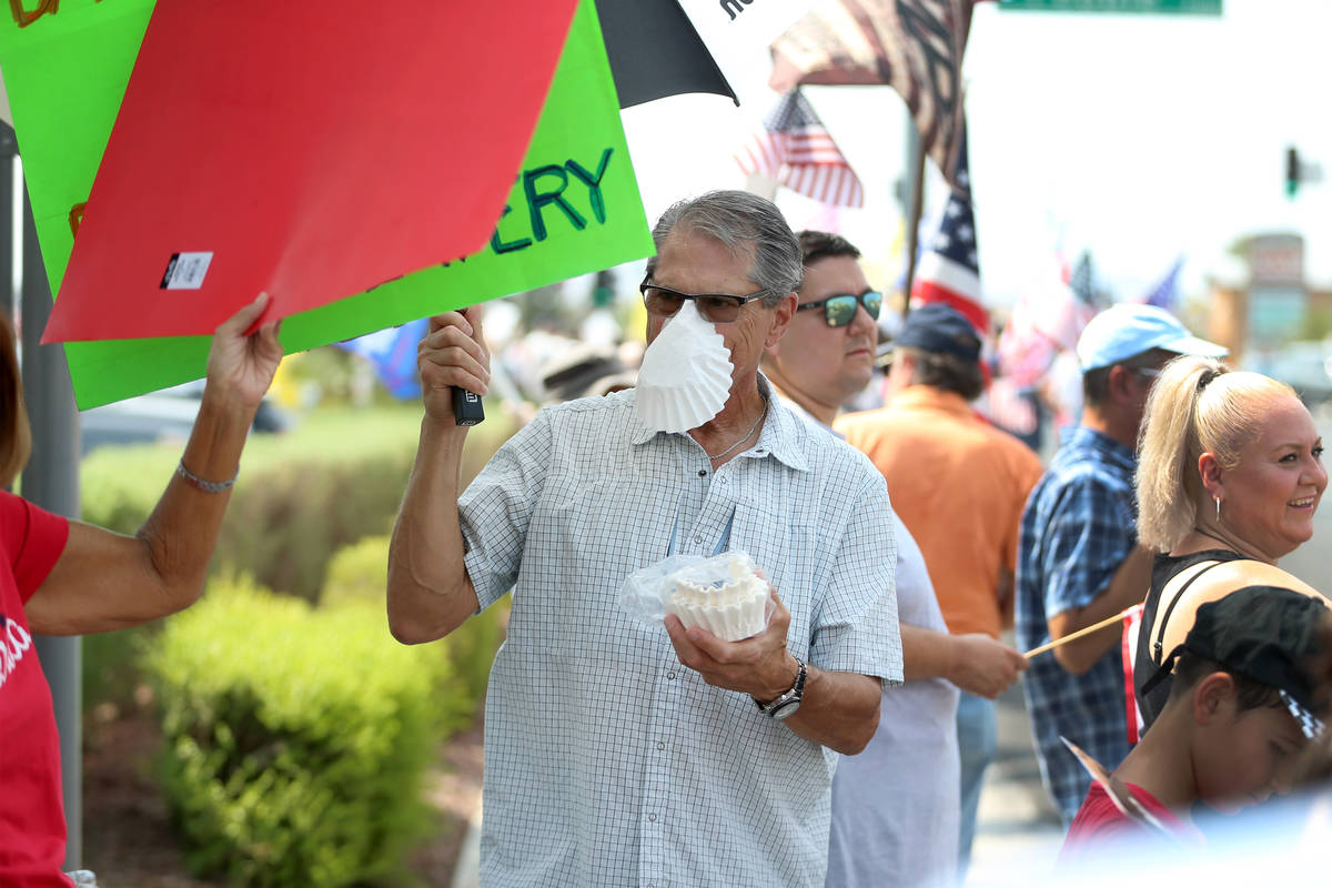 Bill Henggler of Henderson, 72, wears a coffee filter on his face while attending a No Mask Nev ...
