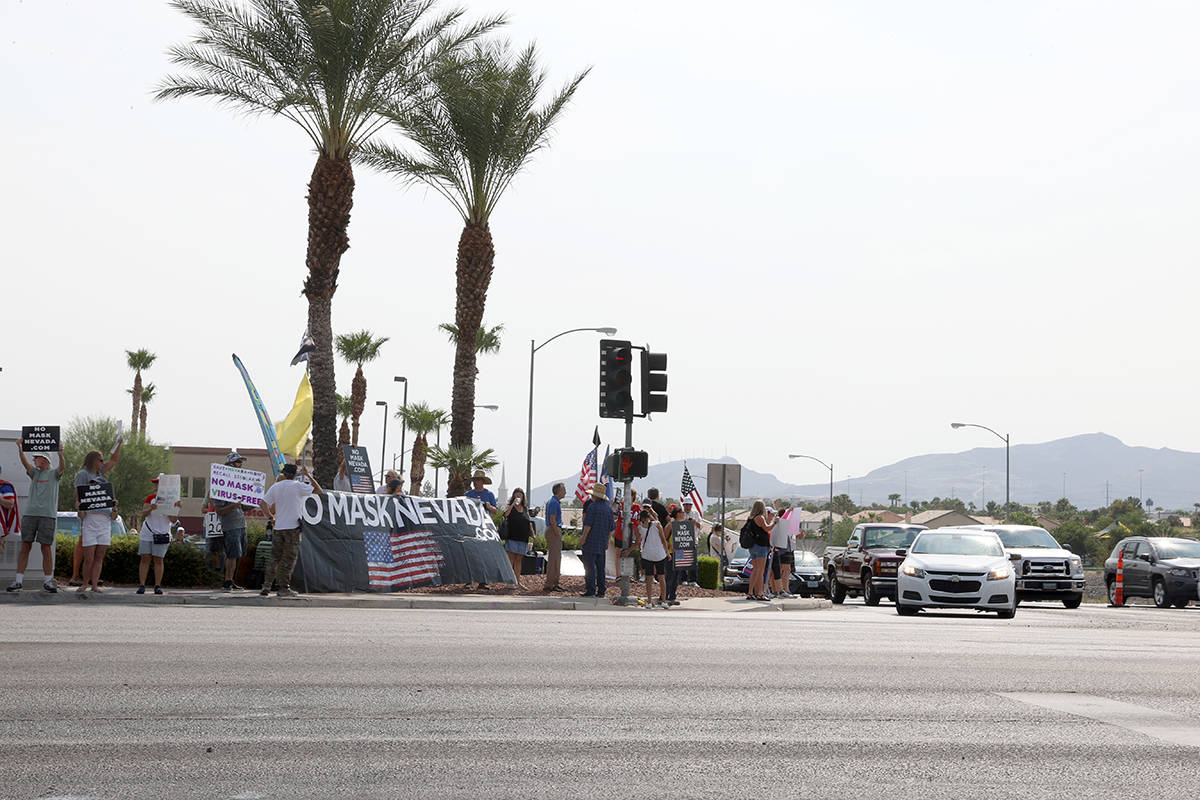 People attend a No Mask Nevada PAC rally at the intersection of Eastern Avenue and Pebble Road ...