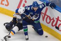 Vancouver Canucks' Elias Pettersson (40) and St. Louis Blues' Ivan Barbashev (49) battle for th ...