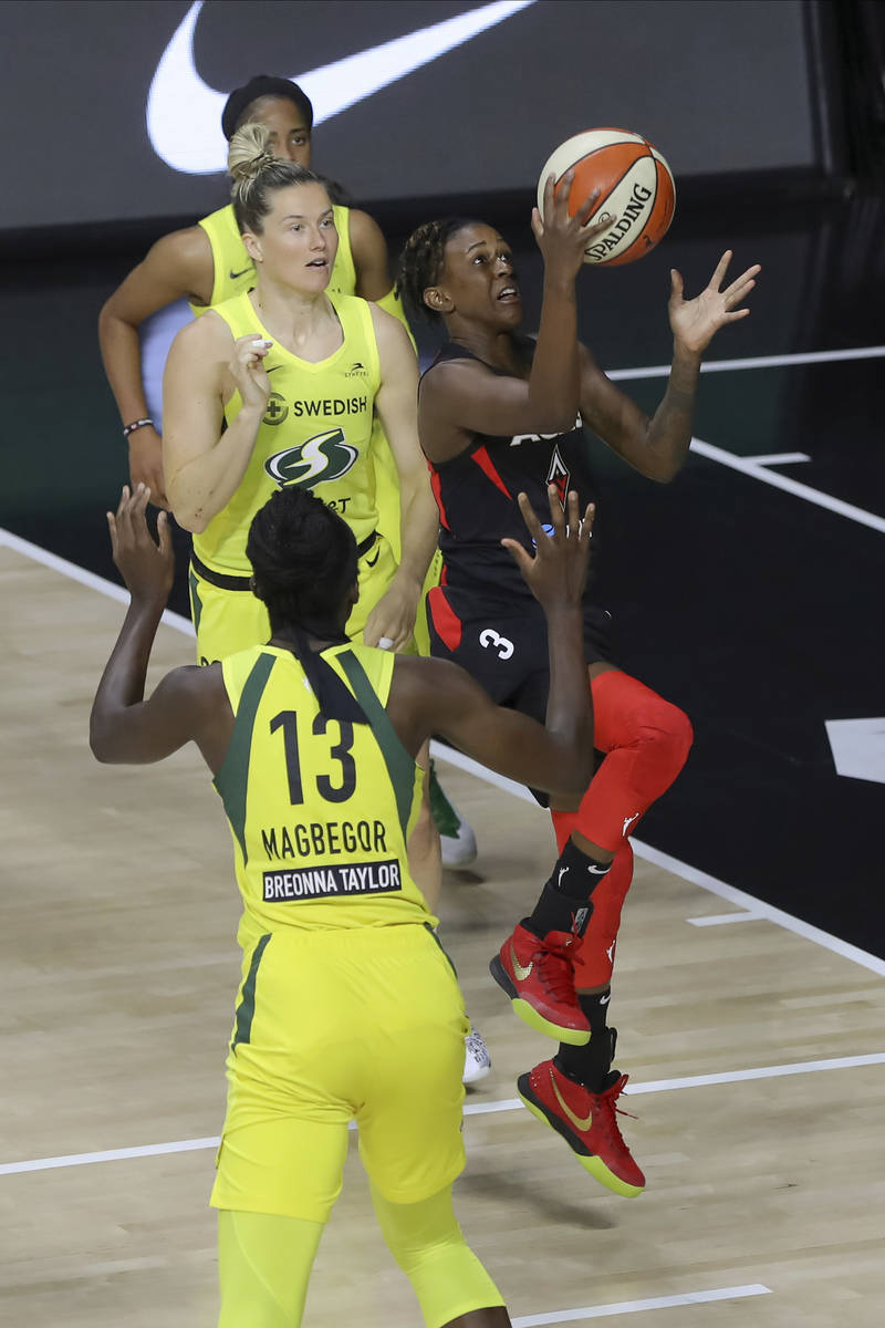 Las Vegas Aces' Danielle Robinson (3) shoots between Seattle Storm's Ezi Magbegor and Sami Whit ...